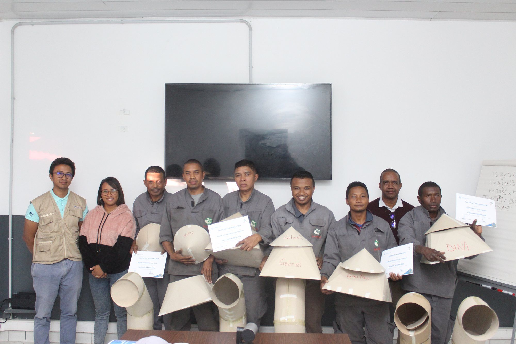 Stagiaires d'une formation en chaudronnerie avec leurs réalisations